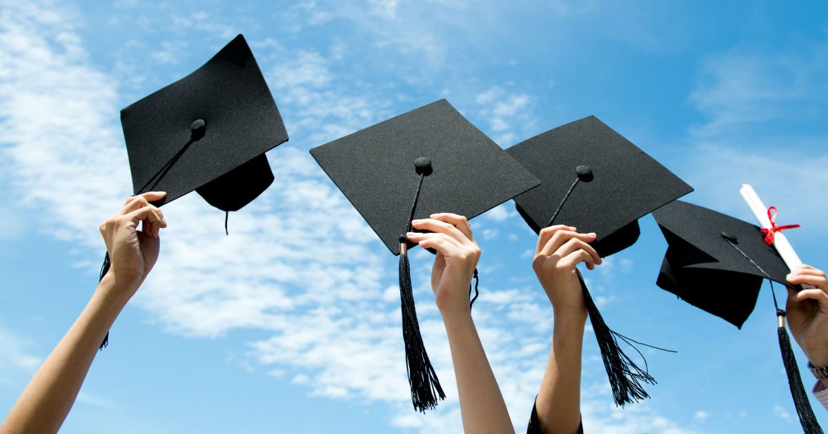 college graduates holding caps