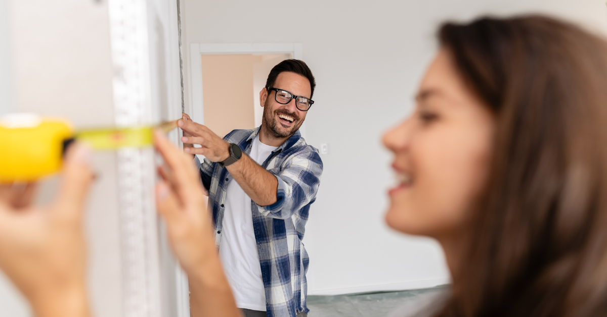 A happy man and woman working on home renovations.