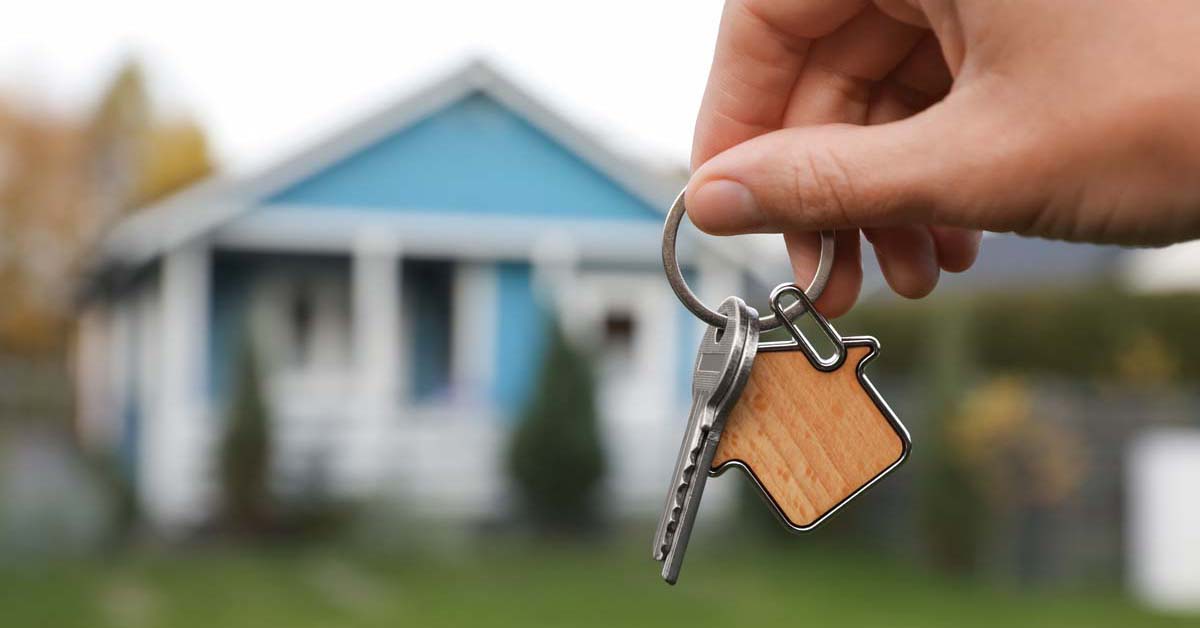 House keys in front of a blue house