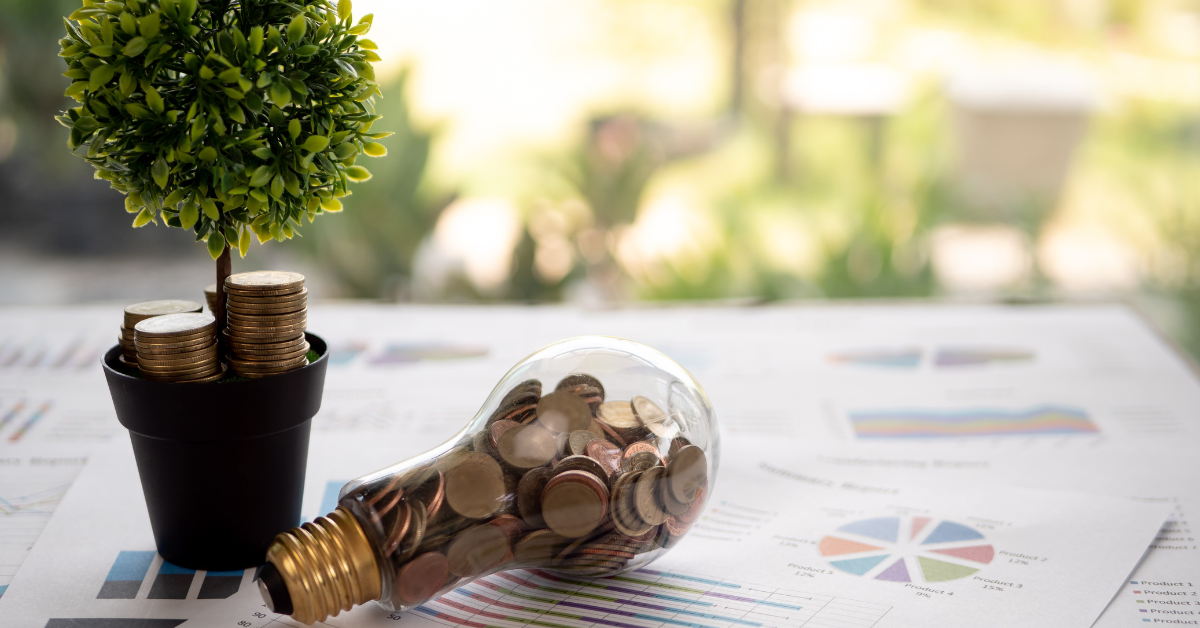 Tree and lightbulb filled with pennies sitting on a pile of papers