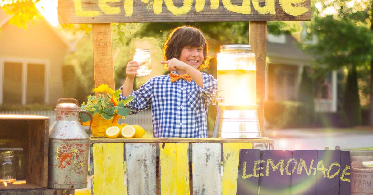 Young boy at a lemonade stand selling lemonade