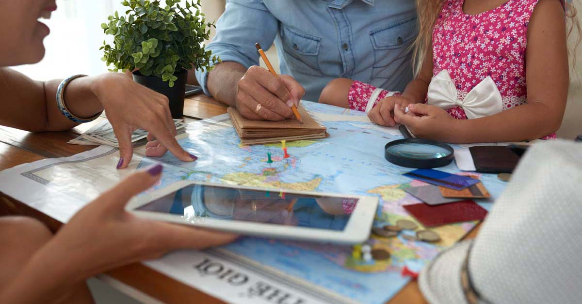 Family planning vacation using a map and a tablet 