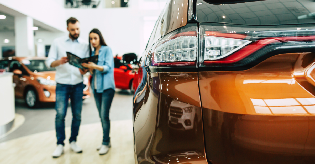 Man and woman at a car dealership shopping for a new car 