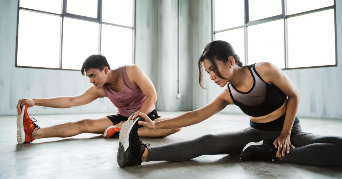 A man and a woman stretching in fitness clothing 