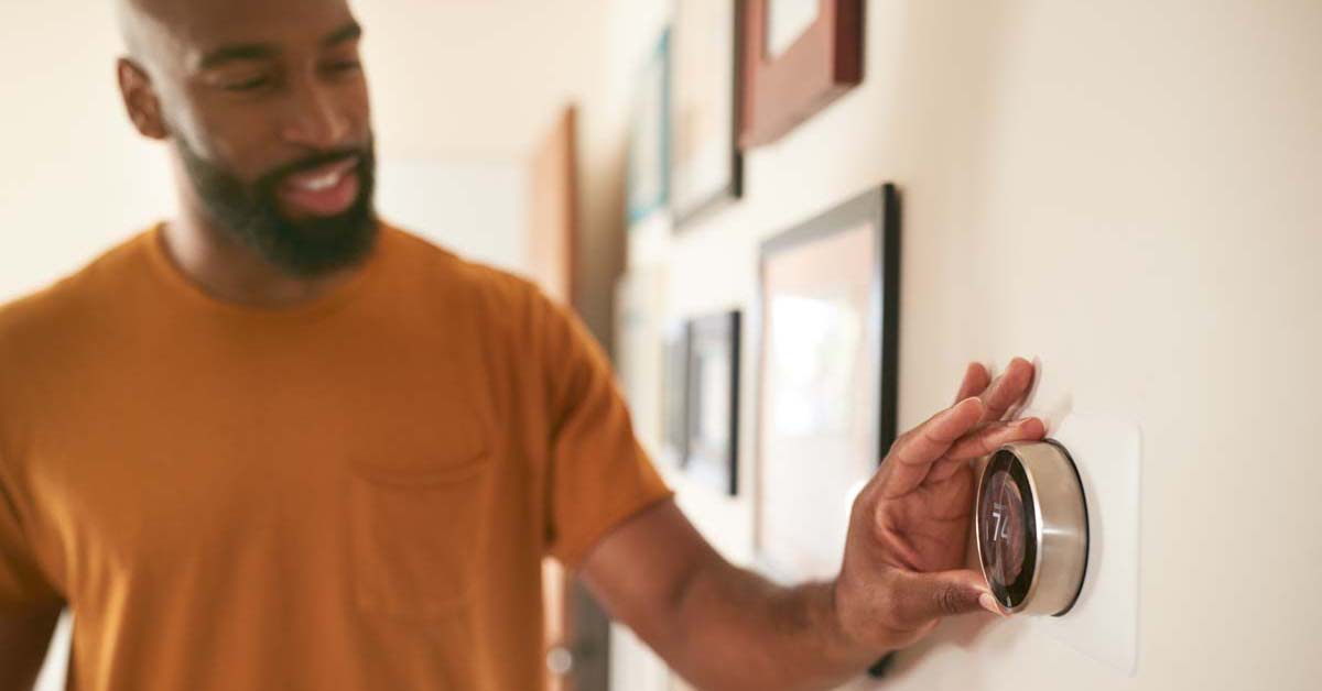 Man adjusting home thermostat 