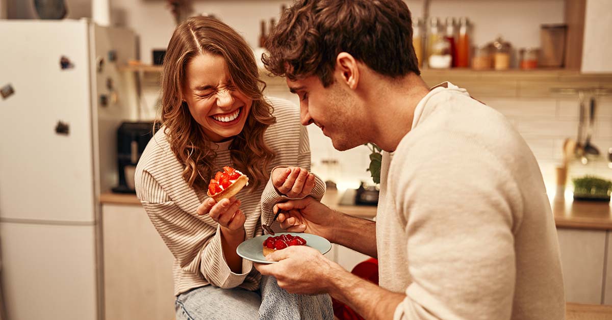 Happy couple eating dessert in a kitchen 