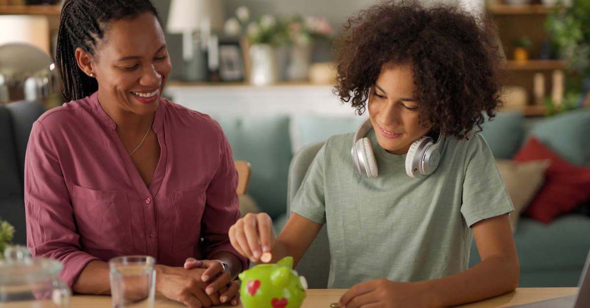 Woman and child smiling putting coins into a piggy bank