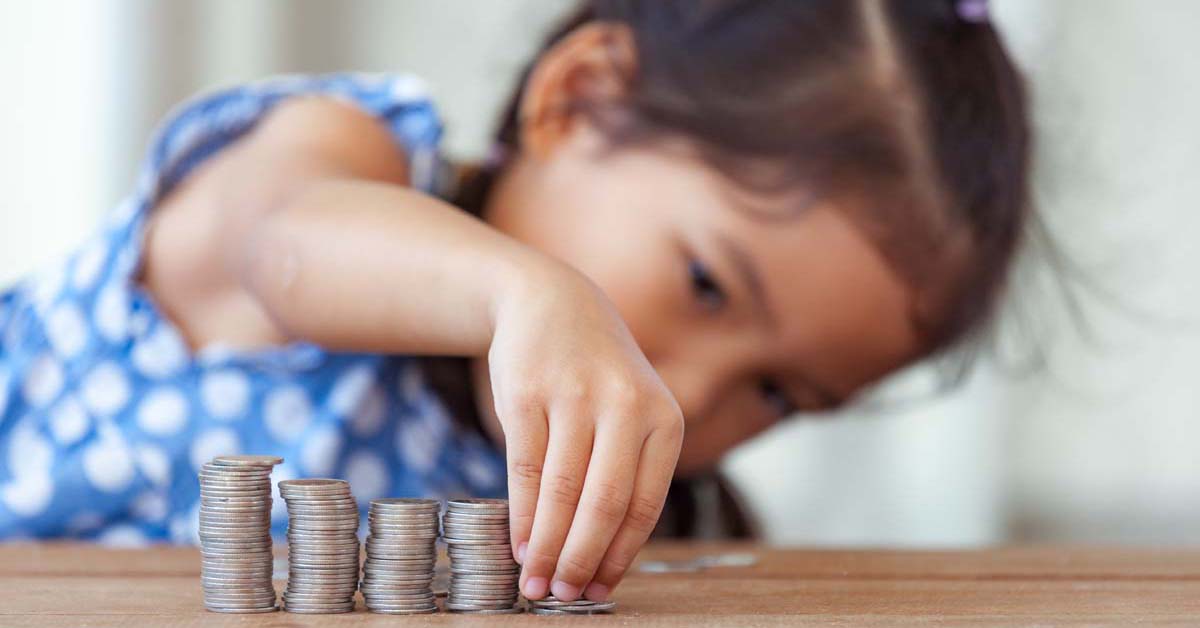 Child counting coins on a desk 