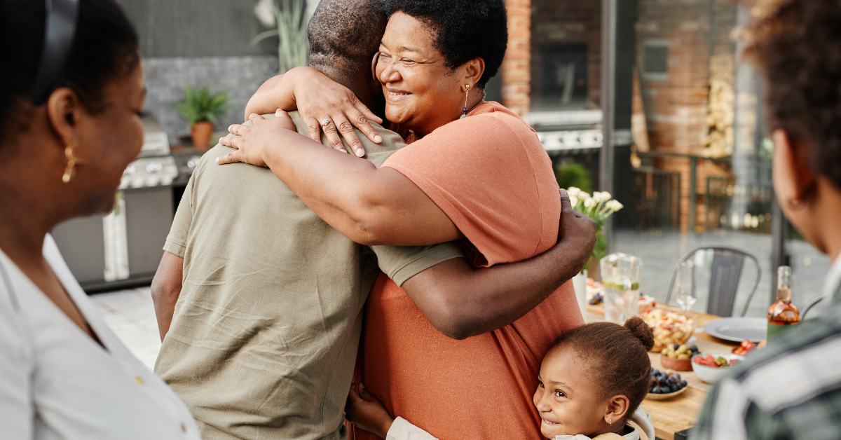 Older woman and young child hugging a family member 