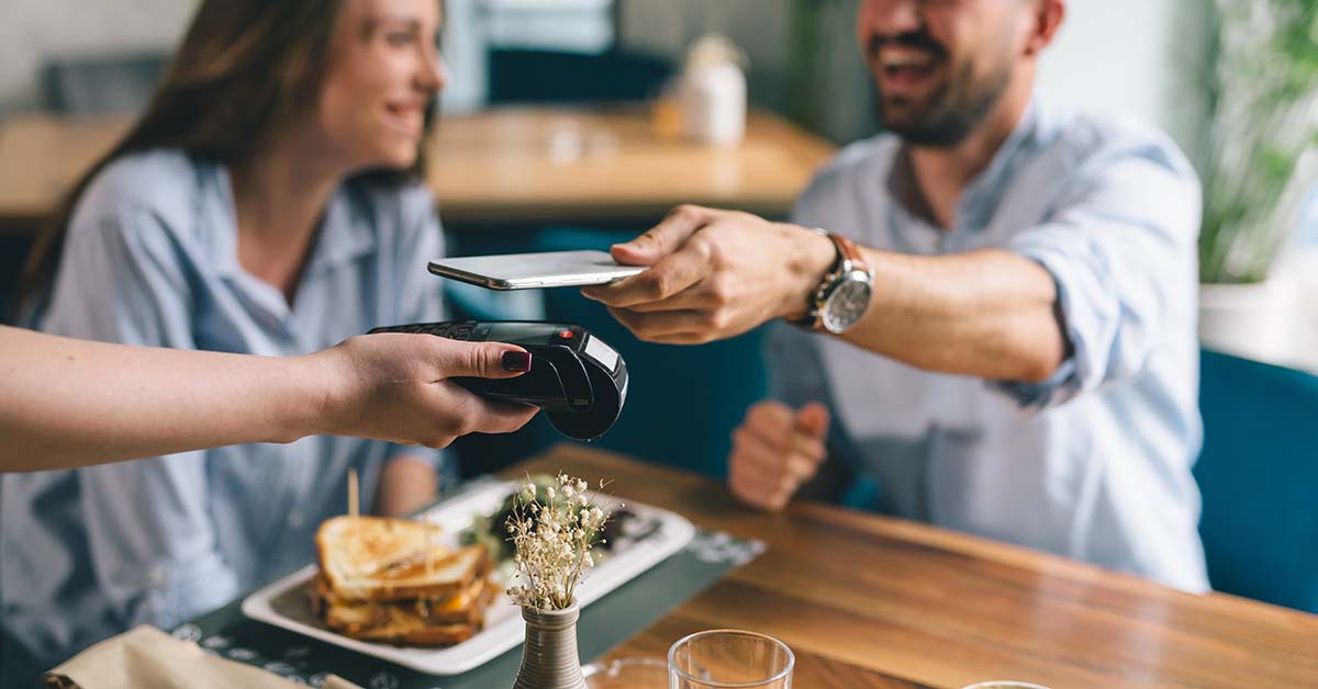 Man using their mobile wallet to pay for lunch