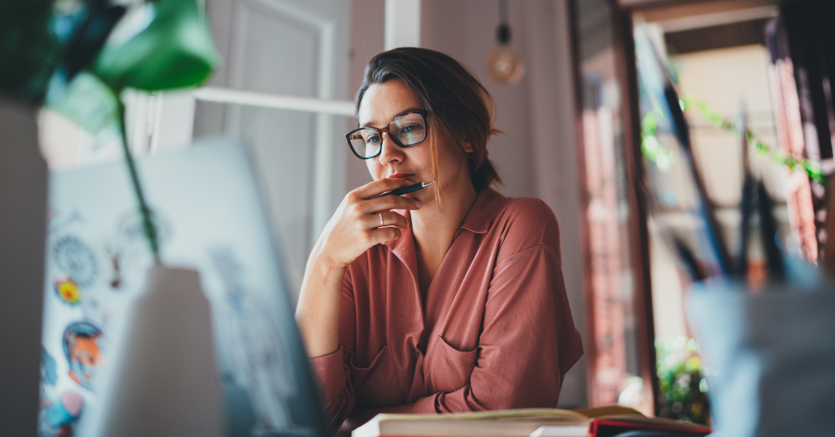 Woman thinking and looking at computer screen