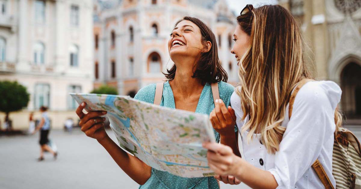 Two girls smiling in a foreign country with a map