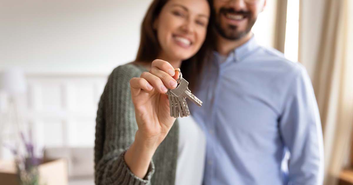 Happy couple holding house keys 