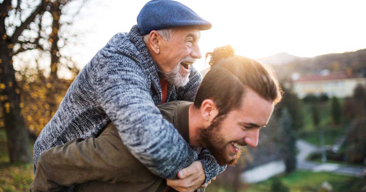 Young man holding an older man on his back