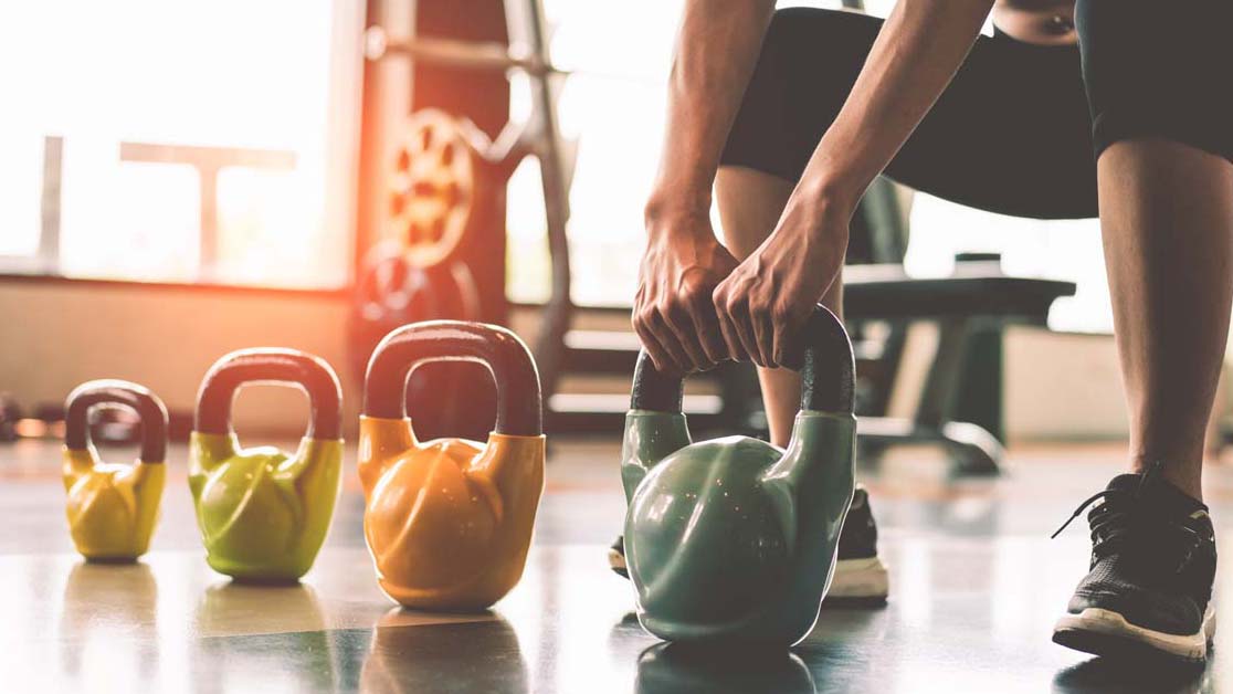 Person exercising with kettlebells 