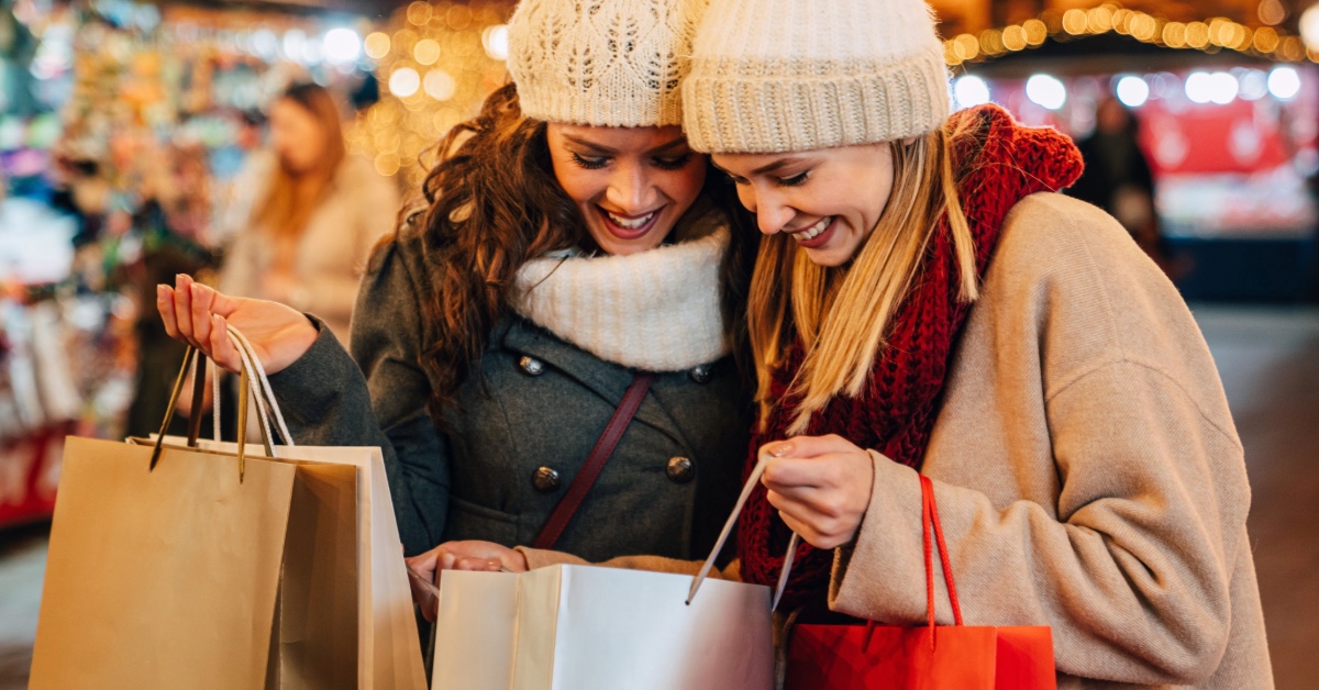 Women smiling with shopping bags.