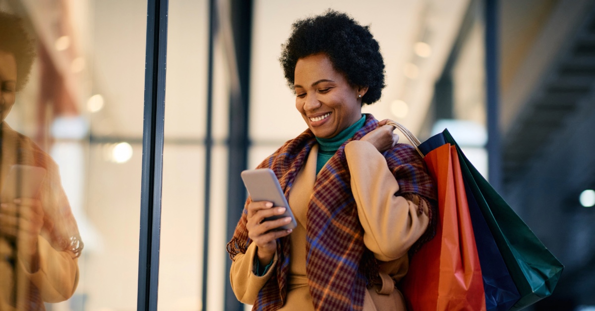 Woman smiling at laptop using online banking for share certificate