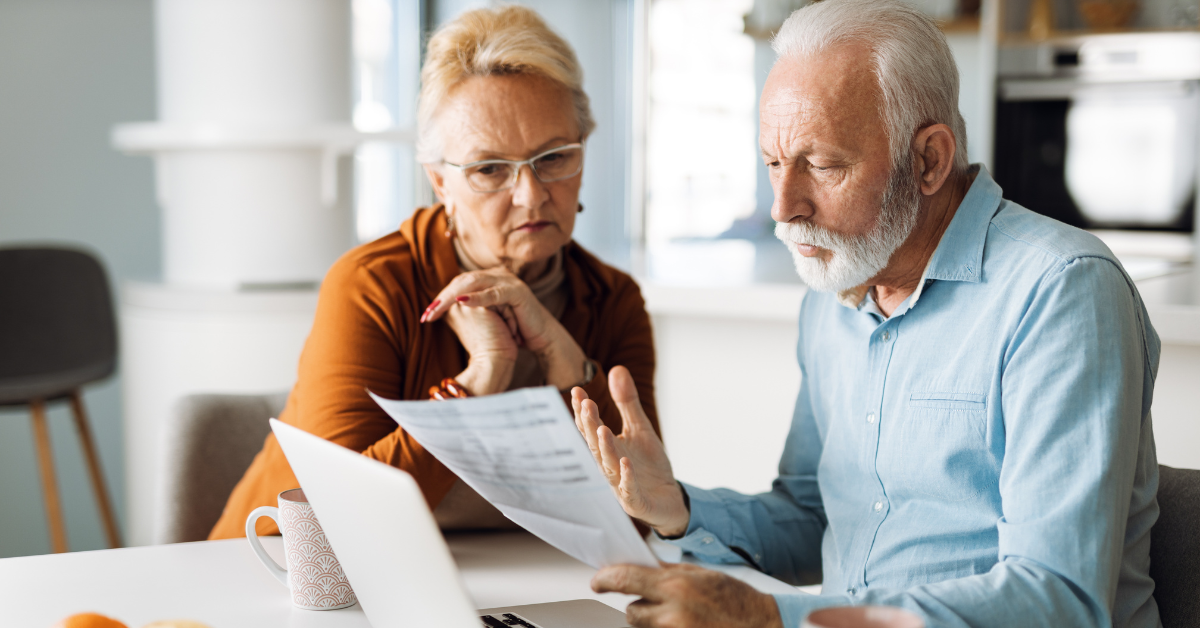 Older man holding a credit card while talking on the phone